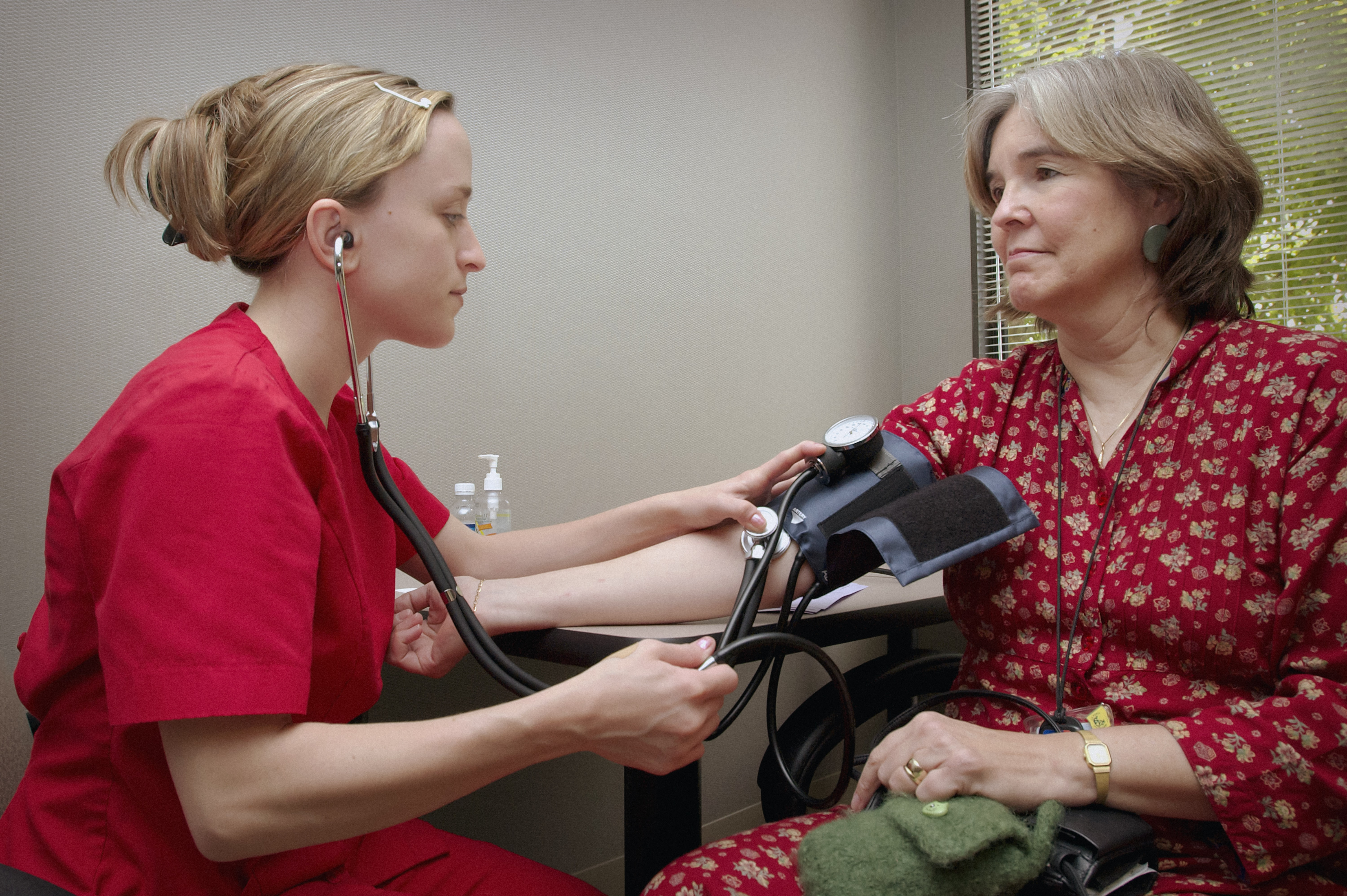 photo of a healthcare professional taking the blood pressure of a patient