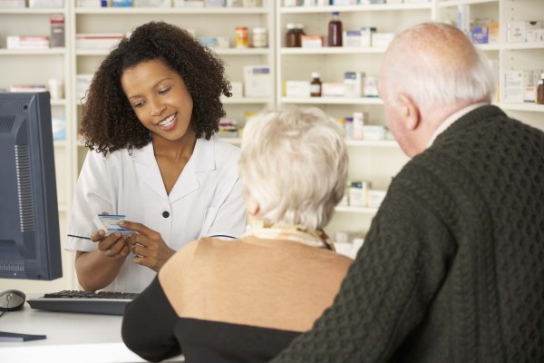 image of a pharmacist explaining the information on the prescription to a couple